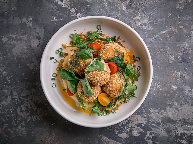 Курячі мітболи з сирним соусом, зеленню, томатами чері та цибулею